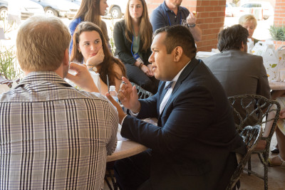 image of several students and professionals                  networking around a table